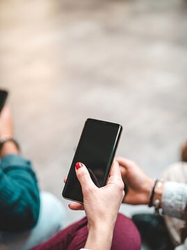 Phubbing concept with woman using smartphone near friends