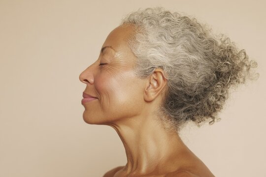 Side profile portrait of an older adult with gray curly hair
