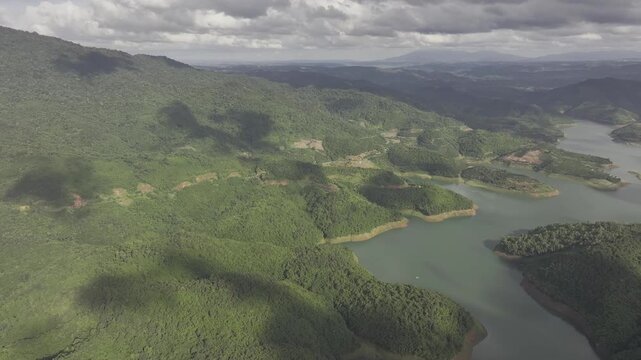 Aerial drone view of Ta Dung Lake surrounded by hundreds of green island hills and mountains in Ta Dung Commune, Lam Dong Province, Vietnam. View from QL 28. D Log mode