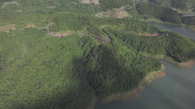 Aerial drone view of Ta Dung Lake surrounded by hundreds of green island hills and mountains in Ta Dung Commune, Lam Dong Province, Vietnam. View from QL 28. D Log mode