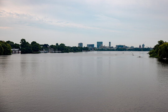 Panoramic view across the Au&szlig;enalster lake under a soft evening sky in Hamburg, Germany.