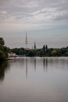 Panoramic view across the Au&szlig;enalster lake under a soft evening sky in Hamburg, Germany.