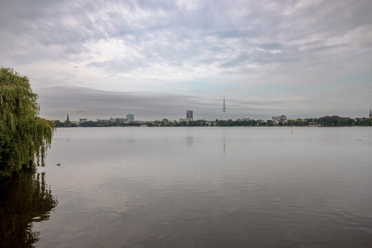 Panoramic view across the Au&szlig;enalster lake under a soft evening sky in Hamburg, Germany.
