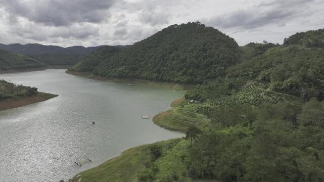 Aerial drone view of Ta Dung Lake surrounded by hundreds of green island hills and mountains in Ta Dung Commune, Lam Dong Province, Vietnam. View from QL 28. D Log mode