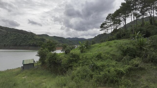Aerial drone view of Ta Dung Lake surrounded by hundreds of green island hills and mountains in Ta Dung Commune, Lam Dong Province, Vietnam. View from QL 28. D Log mode