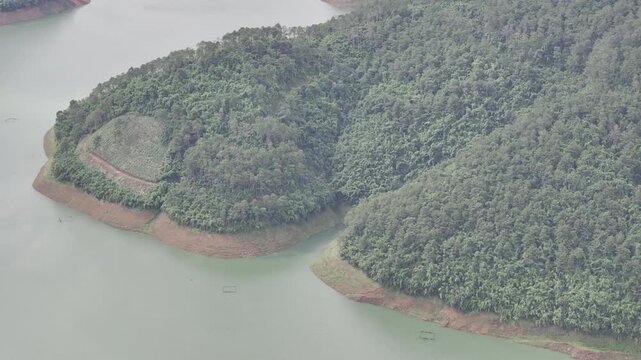 Aerial drone view of Ta Dung Lake surrounded by hundreds of green island hills and mountains in Ta Dung Commune, Lam Dong Province, Vietnam. View from QL 28. D Log mode