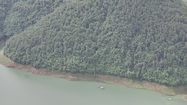 Aerial drone view of Ta Dung Lake surrounded by hundreds of green island hills and mountains in Ta Dung Commune, Lam Dong Province, Vietnam. View from QL 28. D Log mode