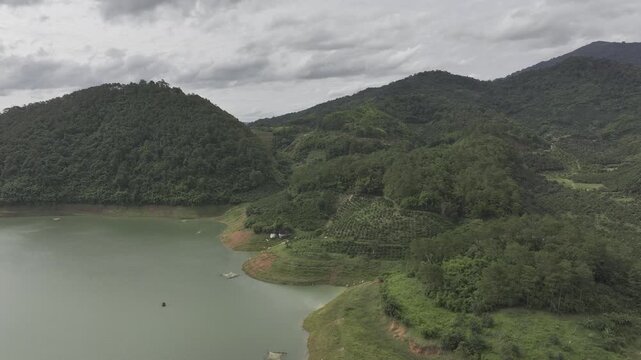 Aerial drone view of Ta Dung Lake surrounded by hundreds of green island hills and mountains in Ta Dung Commune, Lam Dong Province, Vietnam. View from QL 28. D Log mode