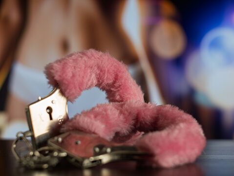 Fluffy Pink Handcuffs on a Wooden Surface