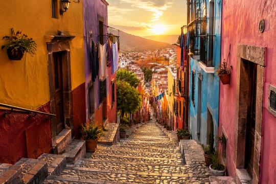Narrow, steep cobblestone alley staircase flanked by vibrantly painted houses.