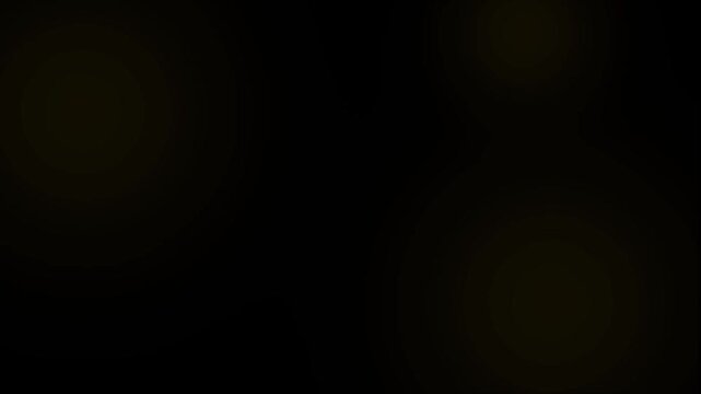 Subtle, dark, and blurred light forms an ambiguous, shadowy glow in the center of an otherwise completely black background, offering a minimalist texture or overlay.