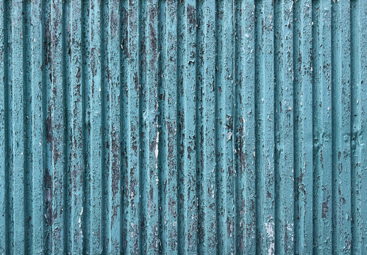 Weathered blue corrugated metal wall with peeling paint texture