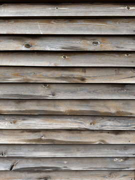 Horizontal weathered wooden planks on exterior building wall