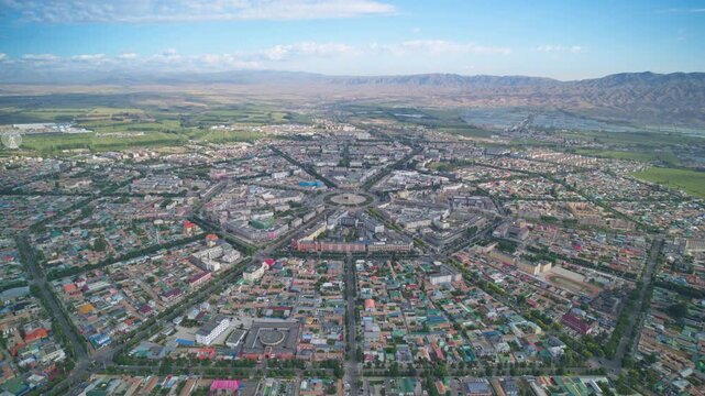 High-Angle Aerial Panoramic View of Tekes Bagua City in Ili: Unique Bagua I-Ching Geometric Layout, Radial Streets, Circular Ring Roads, Blue Sky and Mountain Range in Xinjiang
