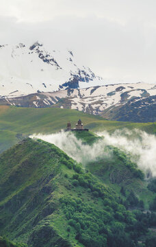 Mountain range landscape, with Gergeti trinity church famous travel destination, in Georgia