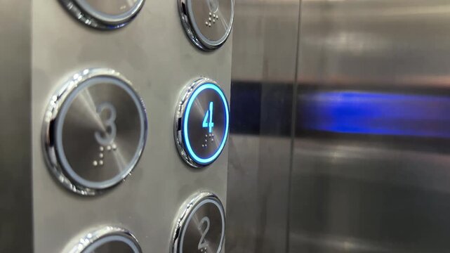 Close Up of Elevator Button Panel and finger press number 4