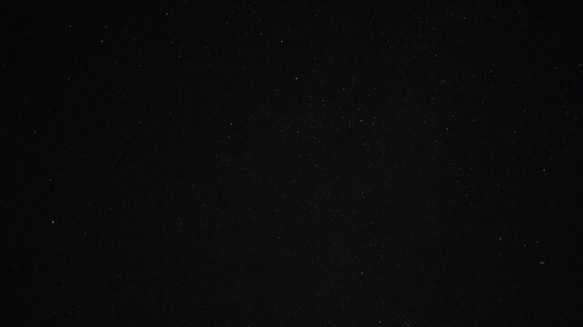 Timelapse video of stars moving across a dark night sky, revealing the subtle motion of the celestial landscape over time. A peaceful astronomy scene ideal for themes of space, stargazing, nighttime,