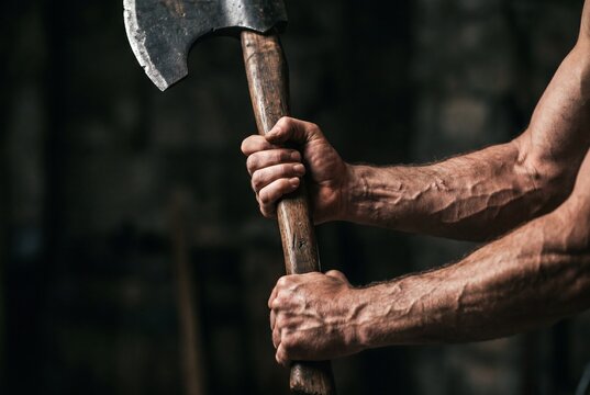 Strong Hands Gripping a Heavy Wooden Axe Handle in Close Up