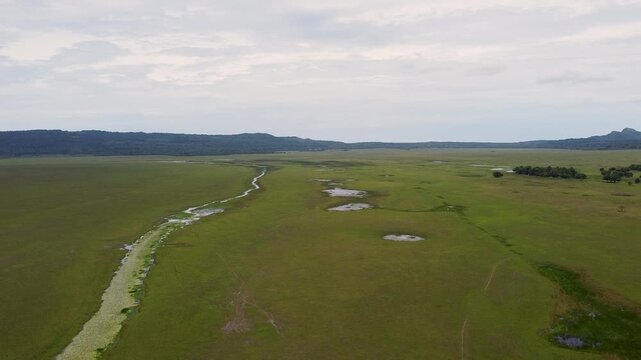 Aerial rising above grassy plains with river and waterholes at Nino Konis Santana National Park of Lautem District, Timor-Leste, Southeast Asia