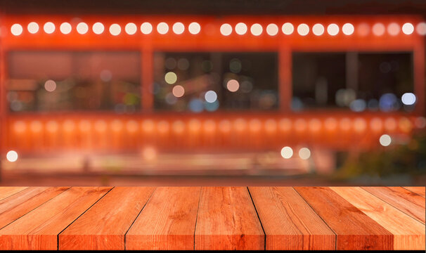 Empty wooden table top with blurred festive bokeh lights at night market
