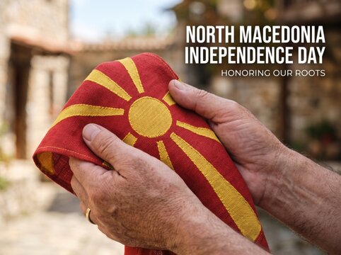 Close up of elderly hands holding a red and yellow fabric north macedonia flag with a blurred stone building background and white text overlay for independence day