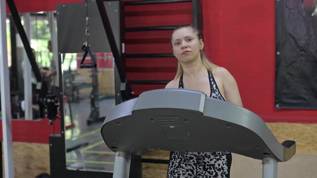 A woman with cerebral palsy walks on a treadmill. 