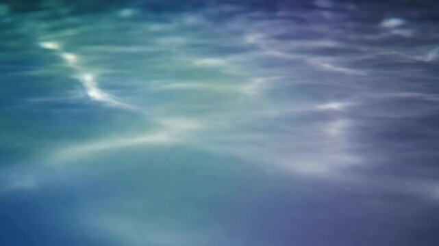Clear blue water surface with rippling waves and caustic light refraction patterns.