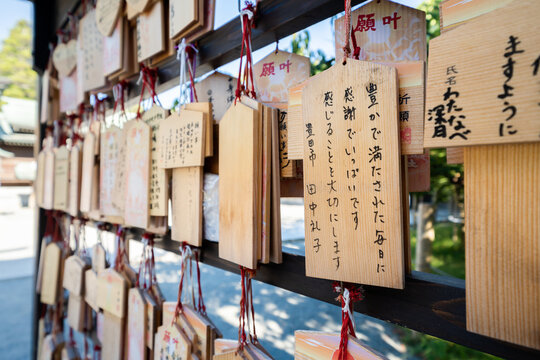 Close-up of wooden ema prayer plaques with Japanese handwritten wishes at Miyajidake Shrine, Fukuoka, Japan