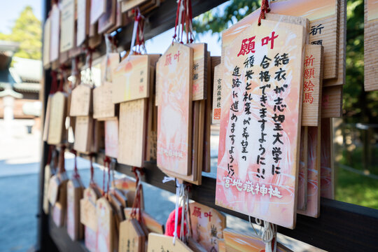 Close-up of wooden ema prayer plaques with Japanese handwritten wishes at Miyajidake Shrine, Fukuoka, Japan