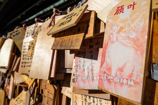 Close-up of wooden ema prayer plaques with Japanese handwritten wishes at Miyajidake Shrine, Fukuoka, Japan