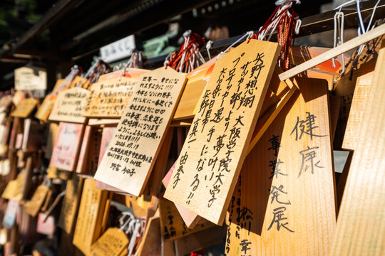 Close-up of wooden ema prayer plaques with Japanese handwritten wishes at Miyajidake Shrine, Fukuoka, Japan