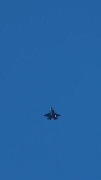 Military Stealth Jet Fighter Flying High in Clear Blue Sky