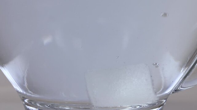 Sugar Cube Dissolving in a Glass Mug of Hot Water