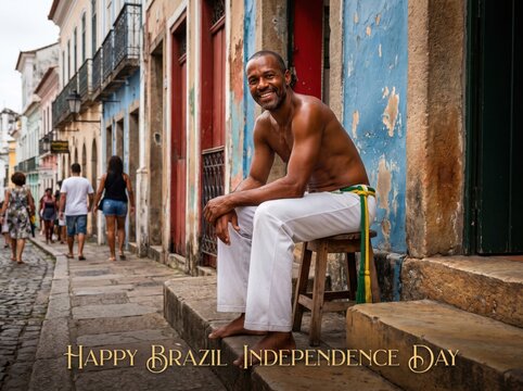 Smiling shirtless man wearing white capoeira pants sitting on a wooden stool in a historic brazilian street with weathered blue walls and cobblestone pavement during the day