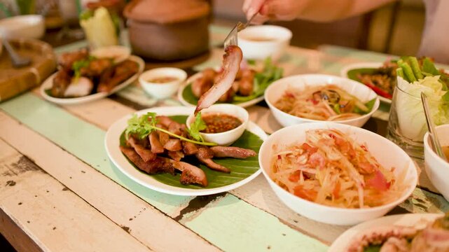 Traditional Thai Isan Cuisine with Grilled Pork and Papaya Salad