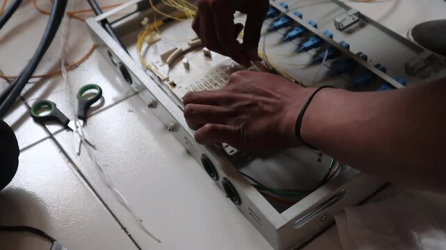 Internet network technicians maintain fiber optic cables in a data center.