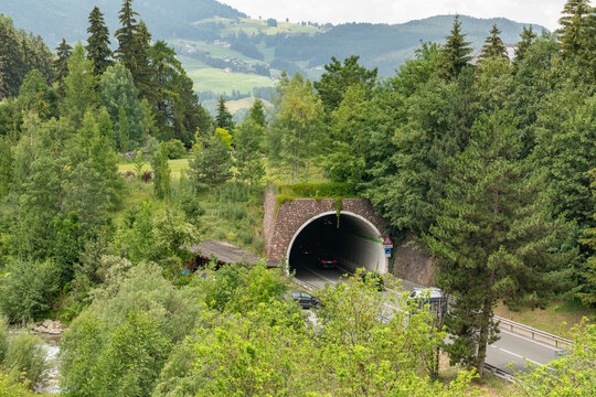 Ortisei, Italy. Alpine tunnel road surrounded by forest, river and mountain landscape