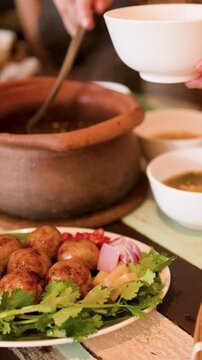 Serving Traditional Thai Isan Food with Clay Pot and Sausages