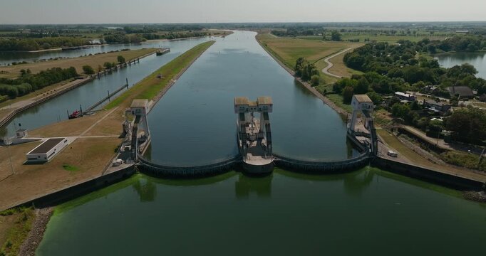 Drone approaches Hagestein Weir on the Lek River, showcasing Dutch water management, river regulation and flood control amid the flat polder landscape.