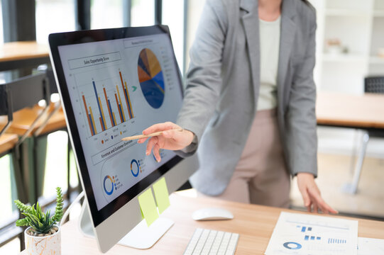 Business Presentation Hand Pointing Pencil At Financial Chart On Monitor