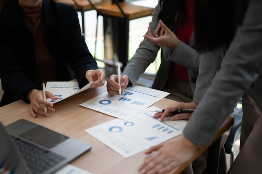 Business Meeting Hands Pointing Pen At Paperwork Charts On Desk Close Up
