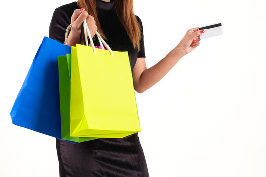 A woman holding colorful shopping bags and a credit card against a white background, representing retail shopping, consumerism, fashion, and payment transactions.concept business
