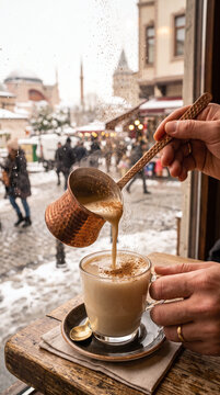 Pouring hot traditional salep with cinnamon on a snowy winter day in Istanbul