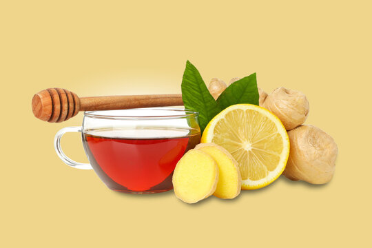Cup of ginger tea sits beside fresh ginger, lemon slices, and honey