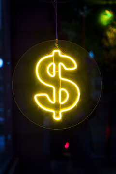Glowing yellow neon dollar symbol sign.