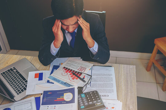 Businessman suffering headache from business disappointed and seriously by bad business results.