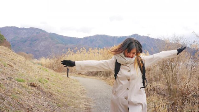 Young Asian woman tourist solo travel Mount Fuji and Lake Kawaguchi in Japan. Female traveler with backpack enjoy sightseeing scenic winter landscape, holiday vacation and Japanese landmark tourism