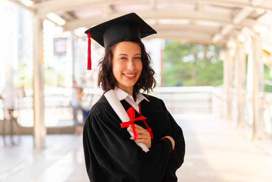 Happy young woman with diploma on graduation day