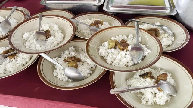 Rows of traditional Indonesian rice dishes on plates ready to serve