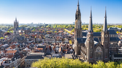 Obraz premium Aerial drone view of Delft with historic cathedrals, panoramic cityscape of old town Delft with traditional Dutch architecture, market square and city center, the Netherlands